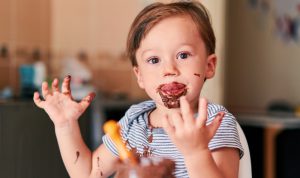 a kid enjoying to have chocolate