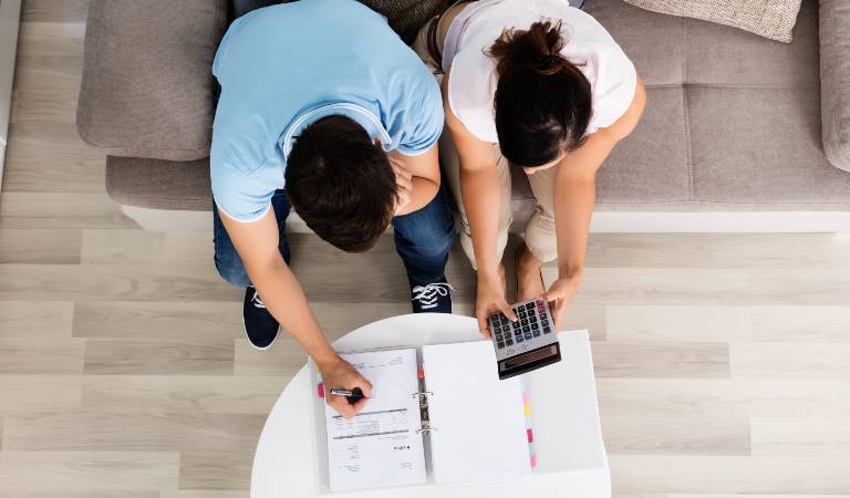 A couple is calculating something in a calculator