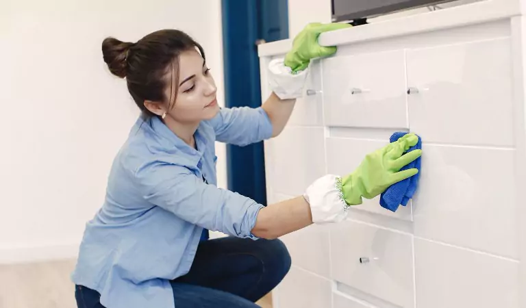young woman wiping a surface with a wipe