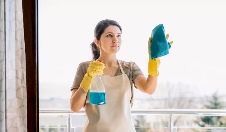 young woman cleaning a window glass