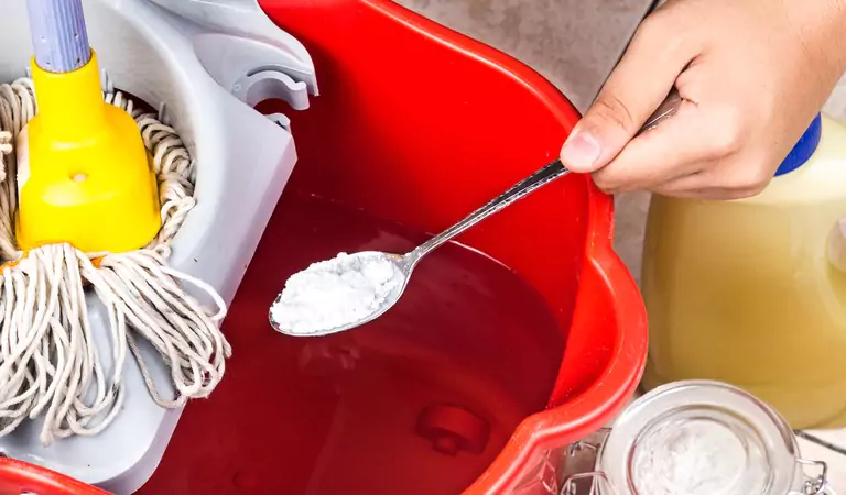 cropped picture of a person puting baking soda in a mop