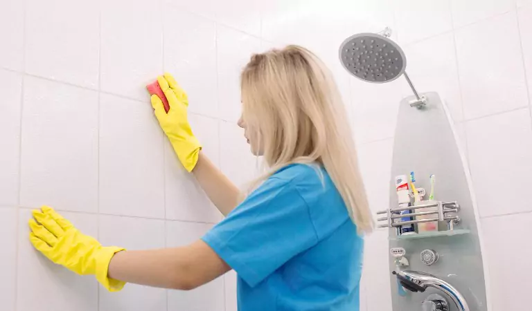 young woman wiping a bathroom surface