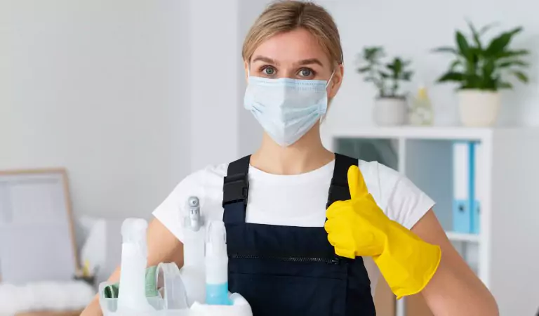 young woman wearing a face mask ready to disinfect her house