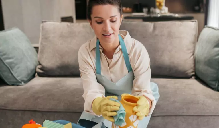 woman cleaning a flower pot inside of a house