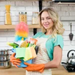 woman with some cleaning supplies inside of a kitchen