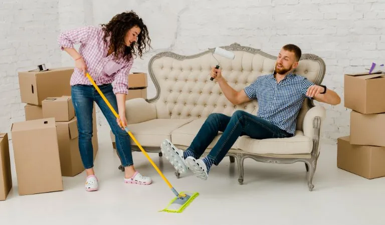 Woman mopping floor near resting man