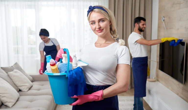 Professional cleaning service team cleans living room in modern apartment