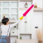 Woman doing dusting in home